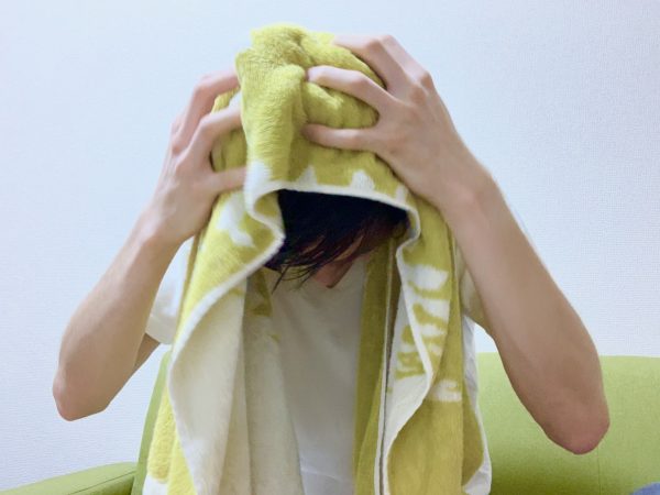 タオルで髪を拭く男性