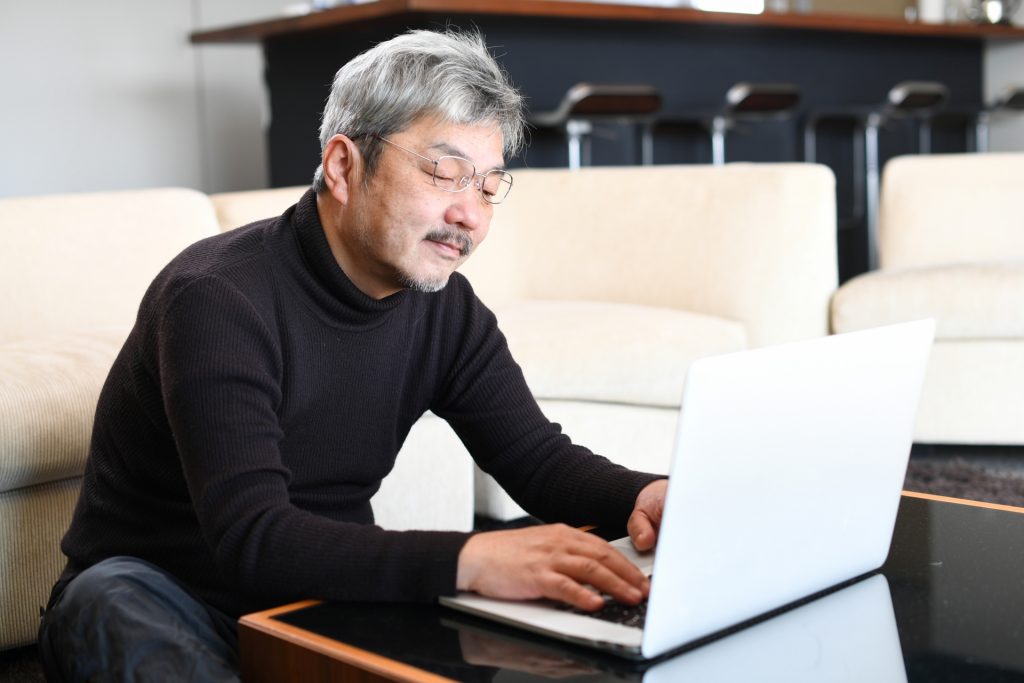 パソコンで仕事をする白髪の男性